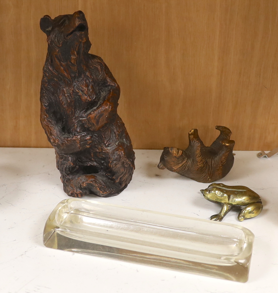 A resin Black Forest bear sculpture, a smaller Black Forest bear (possibly an ink stand but missing glass insert) together with a glass pen dish and brass hinged frog, the largest 25cm high